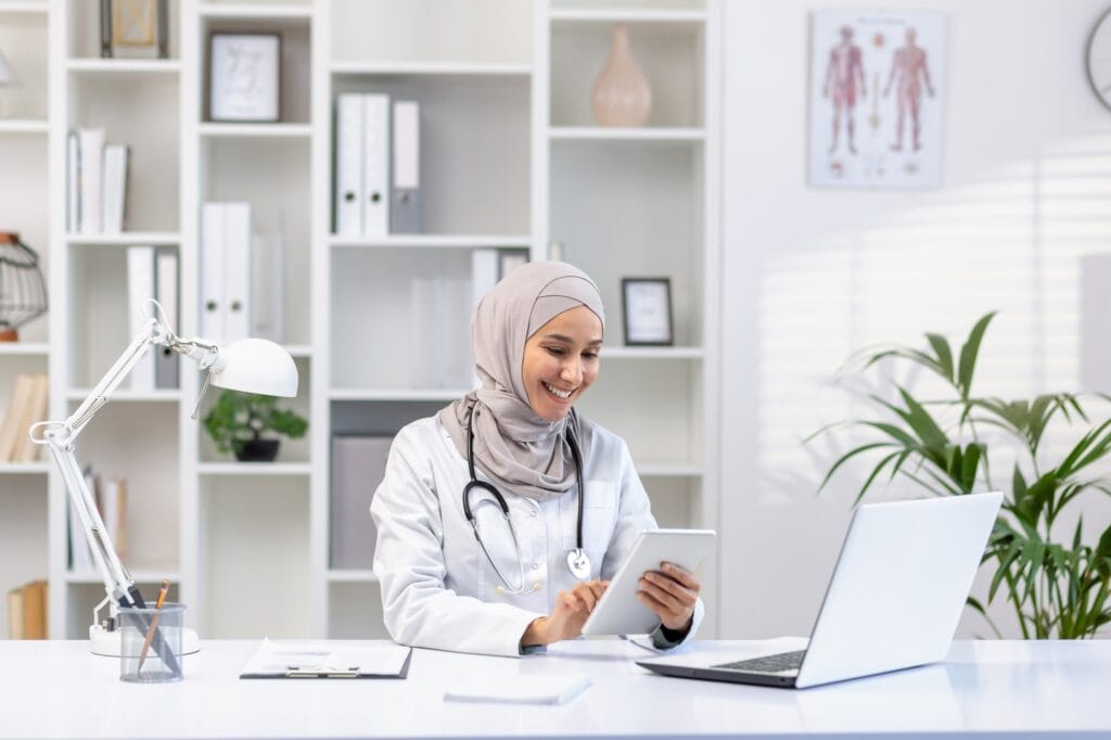 Portrait Muslim female doctor in hijab, woman doctor with tablet computer using application